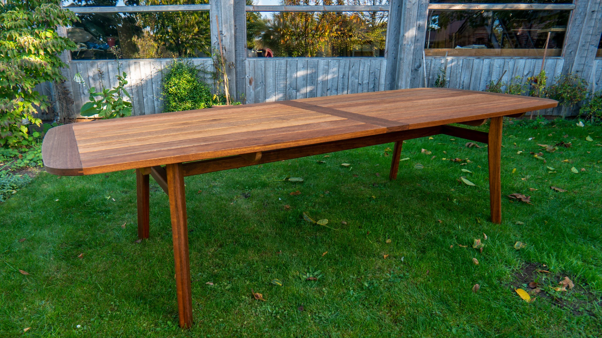 Gartentisch aus dunklem Holz – Bild 1